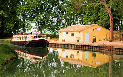 La péniche Béatrice passe devant la Porte Minervoise, près du Somail